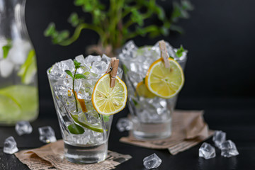 Refreshing summer alcoholic cocktail Margarita with crushed ice, lime and mint for decoration. Vodka splash. On a dark wooden background. On the leaves of the newspaper.