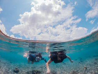 Man and woman snorkeling in the sea, Lipah beach, Amed, Bali.
