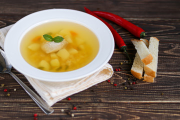 Chickpea soup on a wooden background. Near red chilli greens.