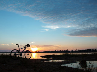 Naklejka na ściany i meble bicycle on the lake at sunset