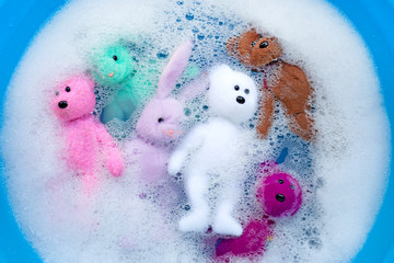 Soak rabbit dolls with  bear toys in laundry detergent water dissolution before washing.  Laundry concept,