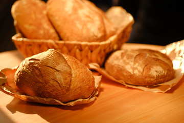Assortment of baked bread on wooden table background. Bread background, top view of white, black and rye loaves. Healthy food. 