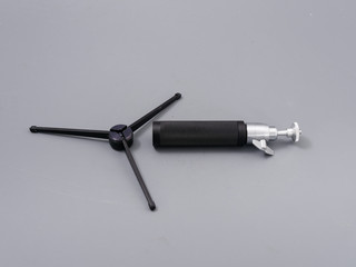 metal mini tripod for the camera on a gray background