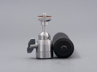 metal mini tripod for the camera on a gray background