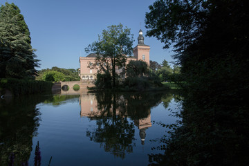 Fototapeta na wymiar Moated castle with park landscape in the Rhineland