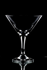 A glass of red wine and a bottle on a black background.