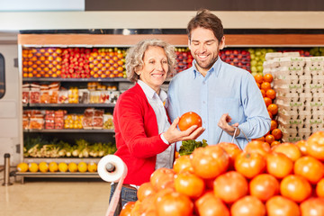 Man and a senior woman buy fresh tomatoes