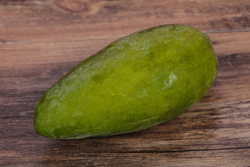 Green tasty mango over wooden background