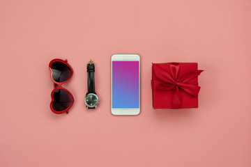 Flat lay image of accessory clothing man or women to plan travel in holiday background concept.Mobile phone & gift box with many item in vacation season.Table top view several object on pink paper.