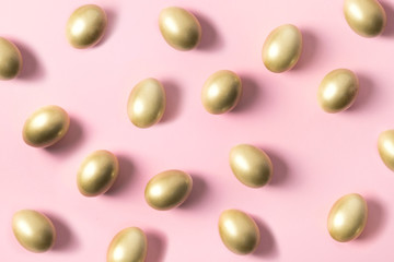 Golden eggs on pastel pink. Creative Easter open composition. Top view. Haster background. Greeting card.