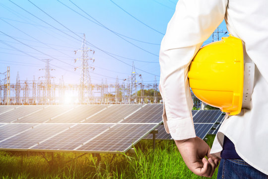 Industry worker or engineer working with power solar panel with High voltage post in blue sky,Alternative energy concept,Elements of this earth image furnished by NASA.