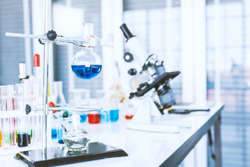 test tubes with lab glassware on the table in laboratory background, research and Scientific concept