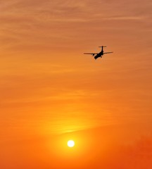 Silhouette Turboprop Aircraft Flying Landing Against The Sun