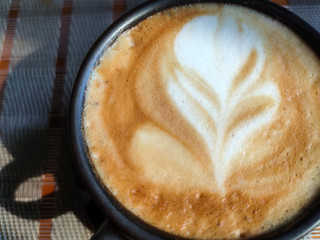 Close-up Cappuccino Coffee on wood table in morning.