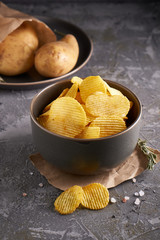 potato chips in a gray bowl on a gray background