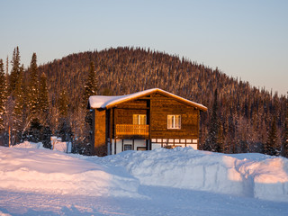 Alpine-style hotel house in the Gornaya Salanga ski resort. The sun rises. Beautiful morning lighting