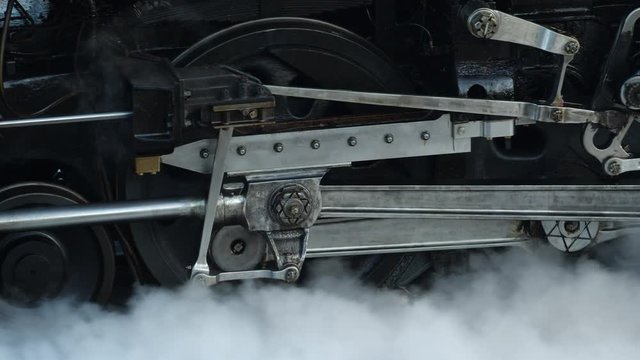 Close shot of connection and coupling rods of UP steam locomotive as it slowly moves