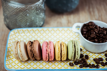 Assortiment de macarons et grains de café sur une assiette colorée