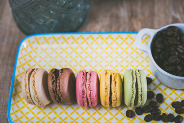 Assortiment de macarons et grains de café sur une assiette colorée