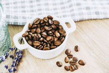 Grains de café dans un petit pot blanc en céramique