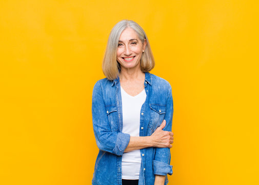 senior or middle age pretty woman laughing shyly and cheerfully, with a friendly and positive but insecure attitude