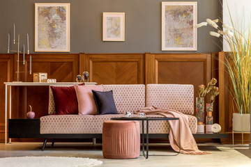 Interior design of living room with stylish velvet sofa, elegant pouf, coffee table, plants,...