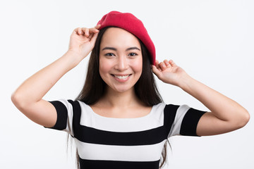 Smiling female fixing her hat