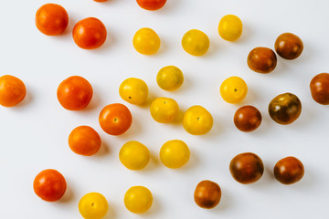 Varieties of cherry tomatoes background, isolated on white, abstraction