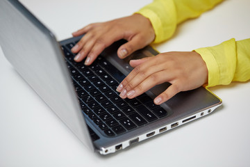 education, technology and people concept - close up of hands of african american woman typing on laptop computer