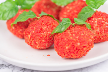 Red dessert like litchi on a white plate