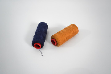 blue and yellow sewing thread on a white background