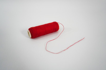 red sewing thread on a white background