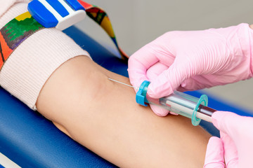 Nurse taking blood with syringe.