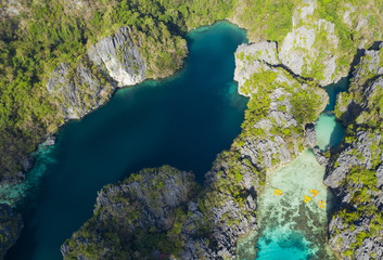 View from above, stunning aerial view of the Big Lagoon and the Small Lagoon, two beautiful bays of crystal clear water surrounded by rocky cliffs. Bacuit Bay, El Nido, Palawan, Philippines.