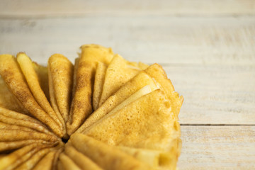 Pancakes on Shrove Tuesday. Beautiful sun-colored pancakes on a wooden background, close-up