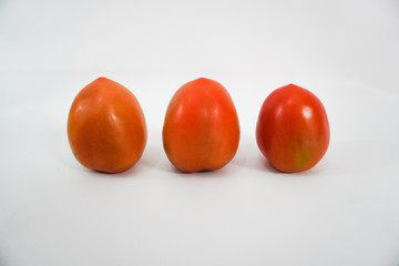three fresh red tomatoes on a white background