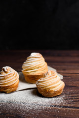 modern cruffins are made from puff croissants in the form of a muffin. on a dark background in powdered sugar. Copy space. the view from the top. close up