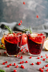 Pomegranate drink in a glass with lemon and rosemary