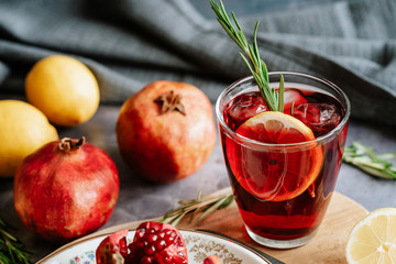 Pomegranate drink in a glass with lemon and rosemary