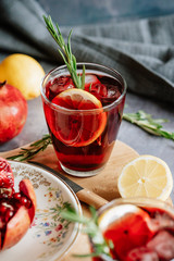 Pomegranate drink in a glass with lemon and rosemary