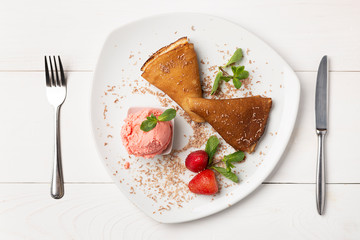 Freshly baked pancakes on a white plate decorated with mint