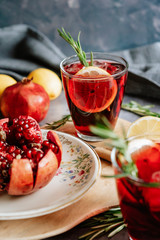 Pomegranate drink in a glass with lemon and rosemary