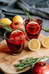 Pomegranate drink in a glass with lemon and rosemary
