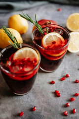 Pomegranate drink in a glass with lemon and rosemary