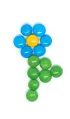 flower of many colored small round candies isolated on a white background