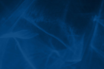 Trendy blue colored low contrast abstract background with light and shadows caustic effect. Light passes through a glass. Water background. 2020 year color trend