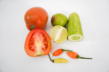 photo of tomato, lemon, cucumber, chili with white background