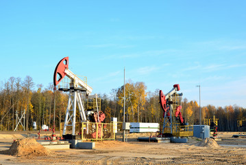 Oil drilling derricks at desert oilfield for fossil fuels output and crude oil production from the ground. Oil drill rig and pump jack.