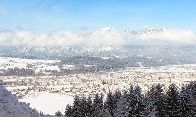 Fototapeta na wymiar Winter panorama of the city with the background of mountains and sky