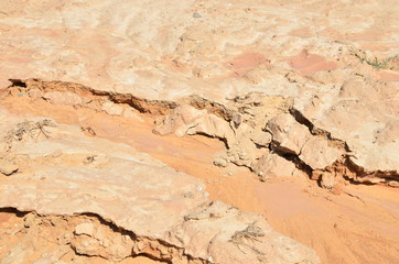 Shattered sand in the ground as a result of heavy torrential rains. Dry cracked soil of the earth due to climate change. Background or texture of the sandy cracks rock under the ground, clay, pebbles